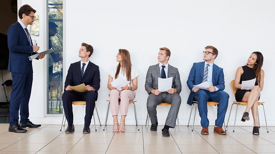 job candidates sitting along wall