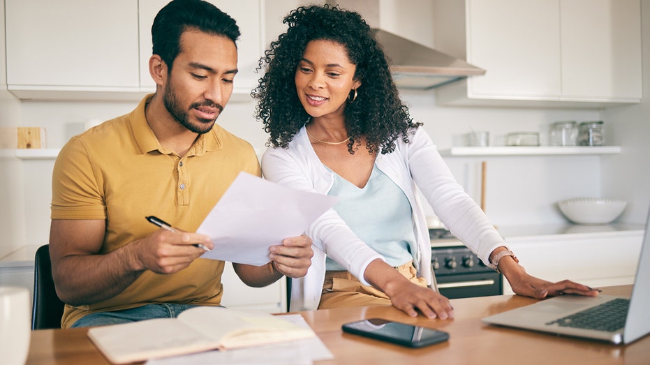 Couple in kitchen going through their finances 