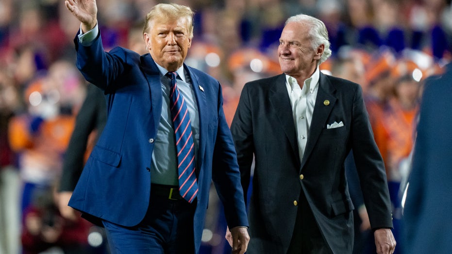 Trump waving to crowd while walking with Henry McMaster