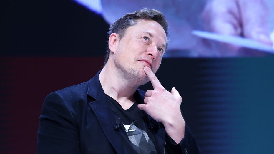 Elon Musk in a thoughtful repose with his finger on his chin