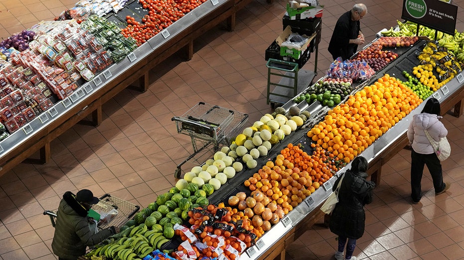 People browse a grocery store produce section.