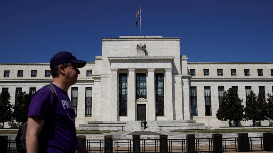 A man walks past the U.S. Federal Reserve in Washington, D.C., in the Foggy Bottom neighborhood.