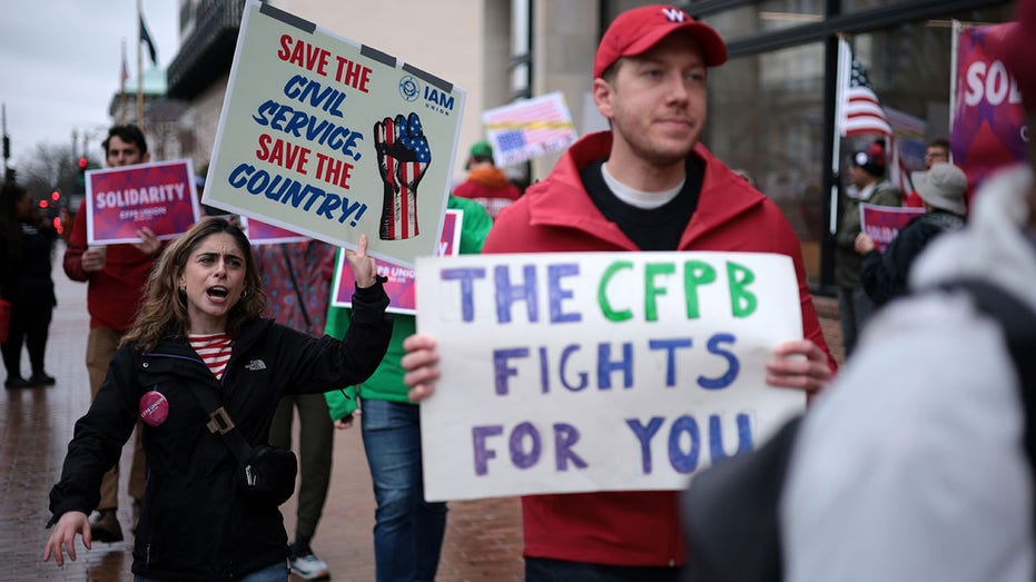 ctivists participate in a rally outside the Consumer Financial Protection Bureau.